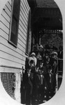 A photo postcard of a group of people standing on the porch of the Methodist Church.
