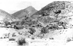 Main Street, right center. Bisbee was a mining camp at this time. Sacramento Hill in center background. The Glory Hole is on the right. Image taken post 1888, as the new smelter has all four furnaces working.