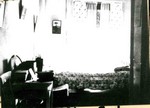 A bedroom in the Young Women's Christian Association, YWCA, showing a bedspread, dresser, and large mirror. The YWCA was located on Howell Avenue in Bisbee.