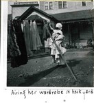 An unidentified woman in a yard on Howell Avenue hanging laundry on a clothesline in Bisbee.