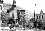 A view of Howell Avenue from the Young Women's Christian Association also known as the YWCA, building. The Copper Queen Hotel and Covenant Presbyterian Church are on the left. A white boarding house is on the right known as the Bessemer House, which was later replaced by the Copper Queen Hospital. Note the automobiles. Photo taken circa 1920s.