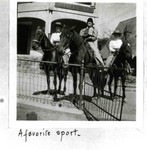 Three women on horseback on street behind metal fence in front of corner building on Howell Avenue. A sign for Royal can be seen behind them. Caption on bottom of photo reads: A favorite sport.