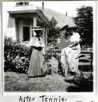 Two women holding tennis rackets on the lawn next to the Bessemer House on Howell Avenue near the Young Women's Christian Association, YWCA.