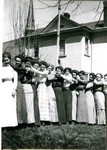 Young women in a line in the yard of the Young Women's Christian Association, YWCA, on Howell Avenue in Bisbee. The Bessemer boarding house in the background.