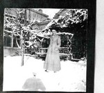 An unidentified woman standing in the snow in the yard of the old Young Women's Christian Association,YWCA, in Bisbee.