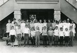 Class photo from Lincoln School, pre-1920. The boys are in the front, the girls are in the back, and the teacher is behind the boys on the left. Many of the boys are barefoot and one has a bandage on his big toe.