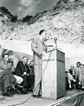 Opening ceremonies for the Mule Pass Tunnel in 1958. Governor Paul Fannin is at the podium. Fannin would likely be the incoming governor when this image was taken, with Ernest McFarland being the current governor of Arizona. The man behind Fannin, with his hand on his knee is possibly McFarland.